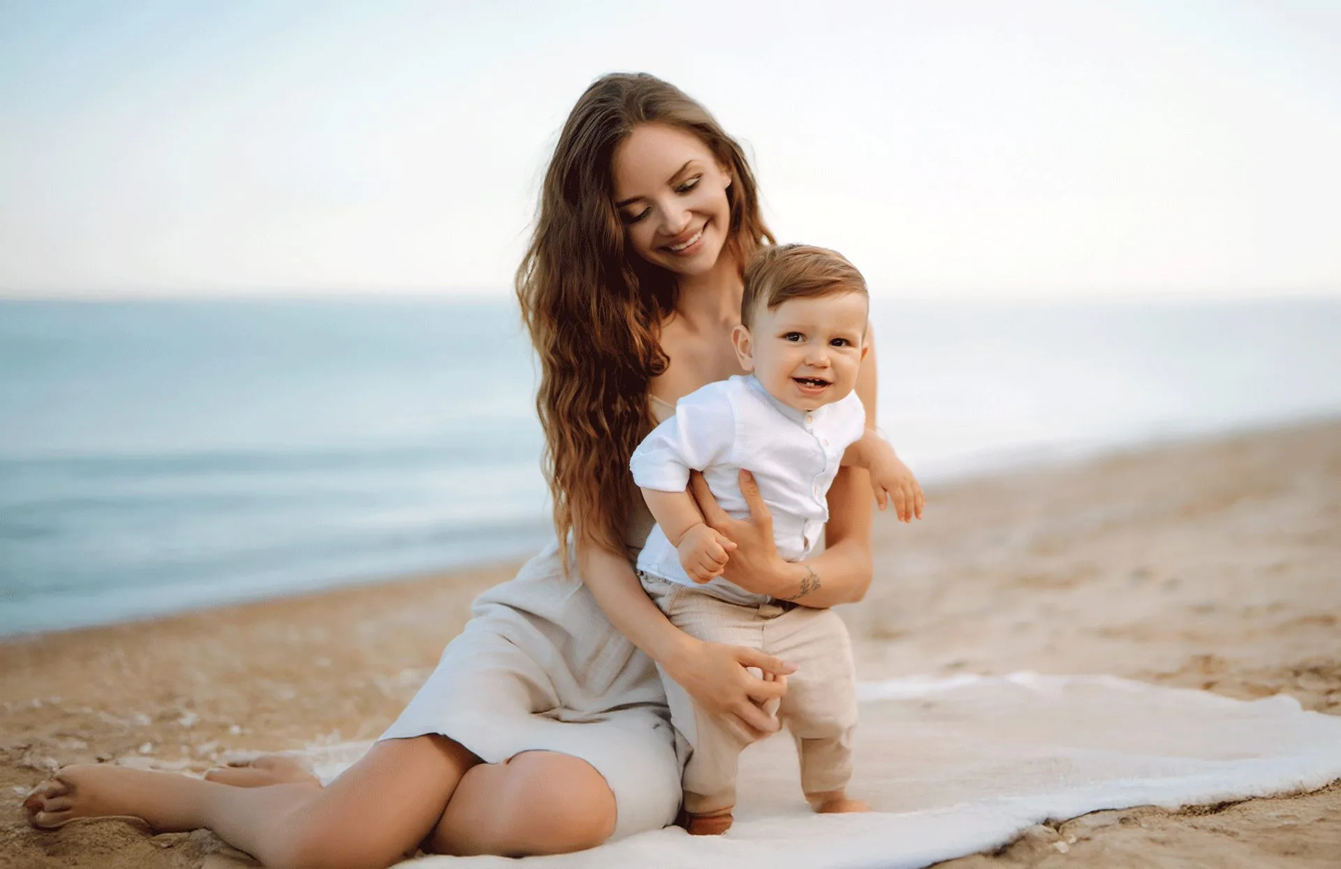 Mother holding her baby on the beachfront